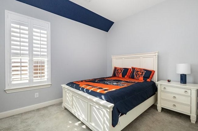 bedroom with vaulted ceiling, light carpet, and multiple windows