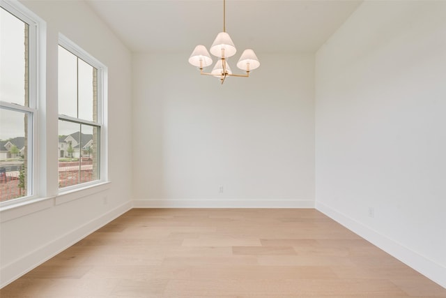 3231 Fisher Rd, Rockwall, TX 75032 - spare room featuring plenty of natural light, a chandelier, light wood-style floors, and baseboards