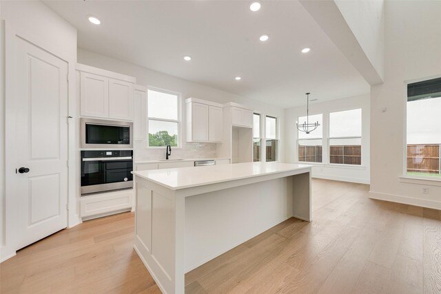 3231 Fisher Rd, Rockwall, TX 75032 - kitchen featuring stainless steel appliances, a sink, a chandelier, light wood-type flooring, and light countertops