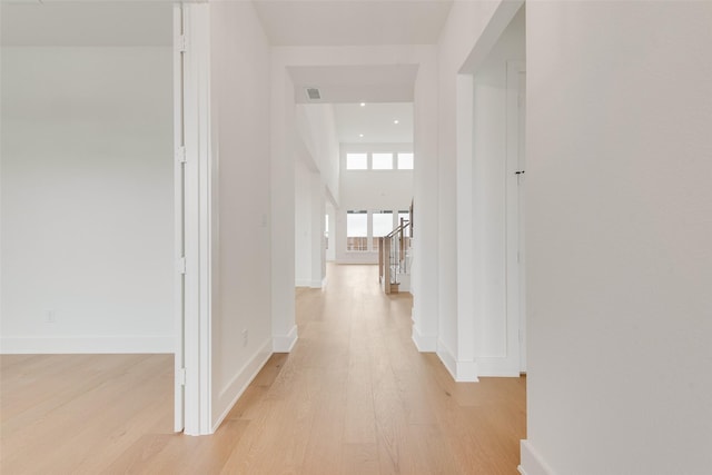 3231 Fisher Rd, Rockwall, TX 75032 - unfurnished living room with a towering ceiling, light wood-style floors, a glass covered fireplace, baseboards, and a chandelier