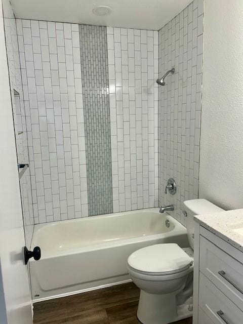 full bathroom with toilet, tiled shower / bath combo, vanity, and hardwood / wood-style floors