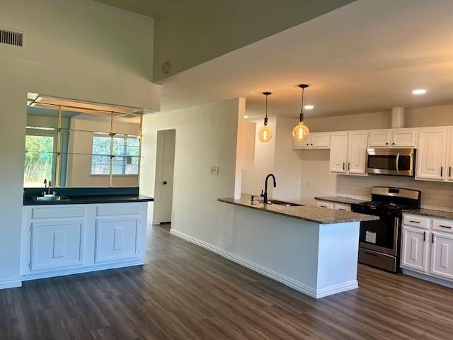 kitchen featuring white cabinets, appliances with stainless steel finishes, sink, and pendant lighting