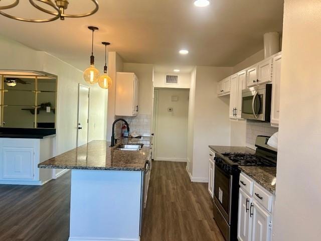 kitchen featuring white cabinetry, decorative backsplash, sink, hanging light fixtures, and black range with gas cooktop