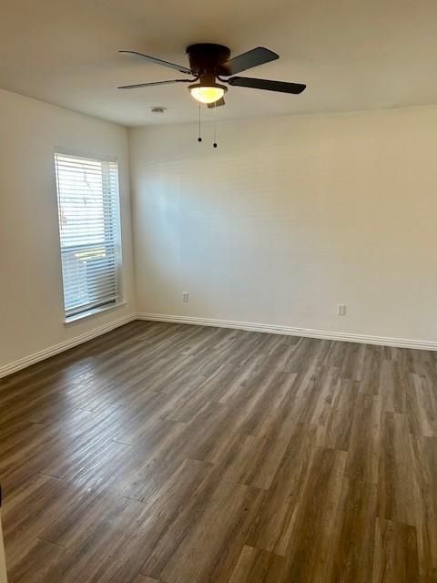 spare room with dark wood-type flooring and ceiling fan