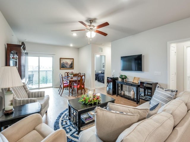 living room featuring light hardwood / wood-style floors and ceiling fan