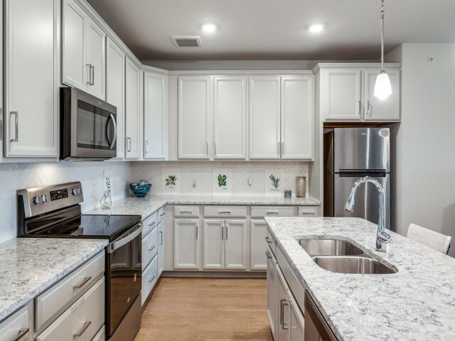 kitchen with backsplash, white cabinetry, sink, and appliances with stainless steel finishes