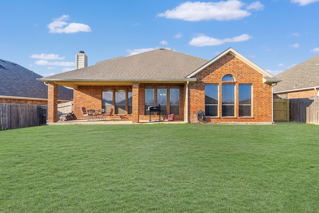 back of house with a patio area and a lawn