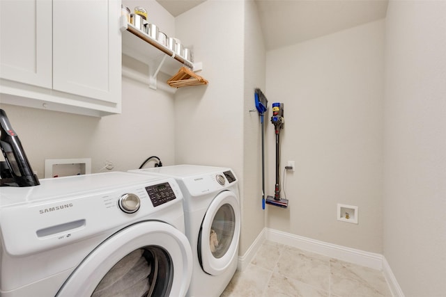 laundry room with washer and clothes dryer and cabinets