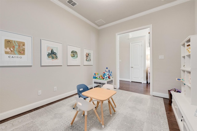 recreation room with dark hardwood / wood-style flooring and crown molding