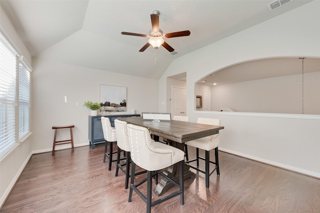 dining space with ceiling fan, wood-type flooring, and lofted ceiling