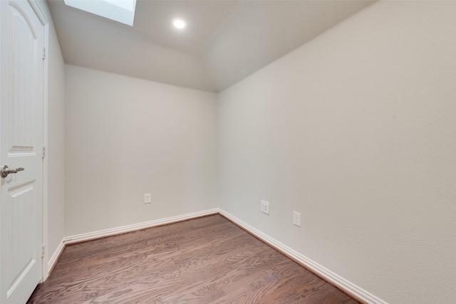 unfurnished room with a skylight and hardwood / wood-style flooring