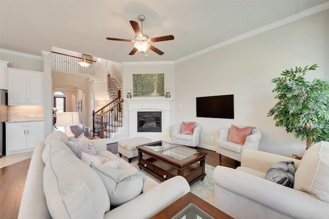 living room with ceiling fan, wood-type flooring, and crown molding