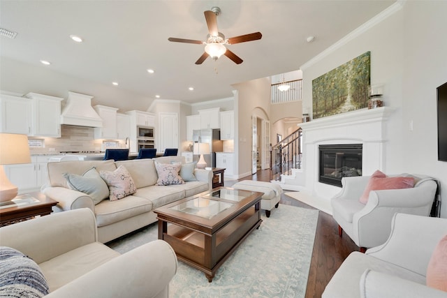 living room with hardwood / wood-style floors, ceiling fan, and crown molding