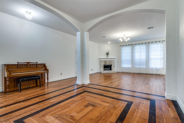 unfurnished living room featuring an inviting chandelier and a fireplace