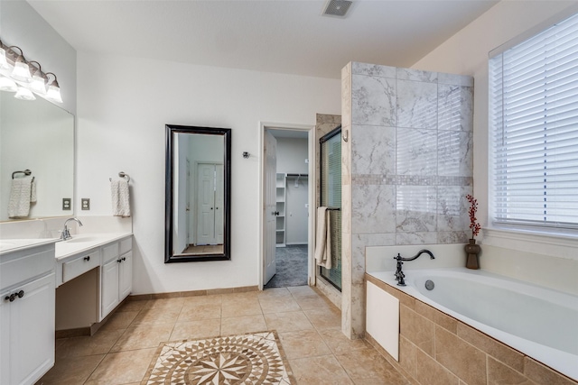 bathroom featuring plus walk in shower, tile patterned flooring, and vanity