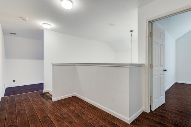 hall featuring dark wood-type flooring and lofted ceiling