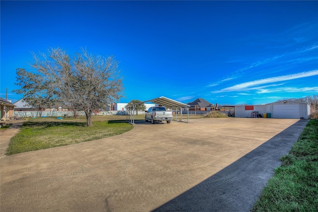 view of yard with an outbuilding, a garage, and a carport