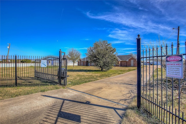 view of gate with a lawn