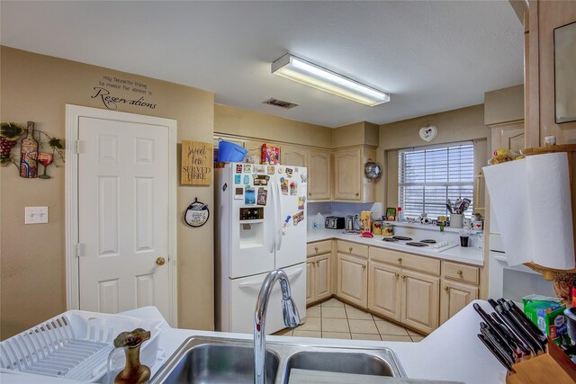 kitchen featuring light brown cabinets, white appliances, sink, and light tile patterned floors