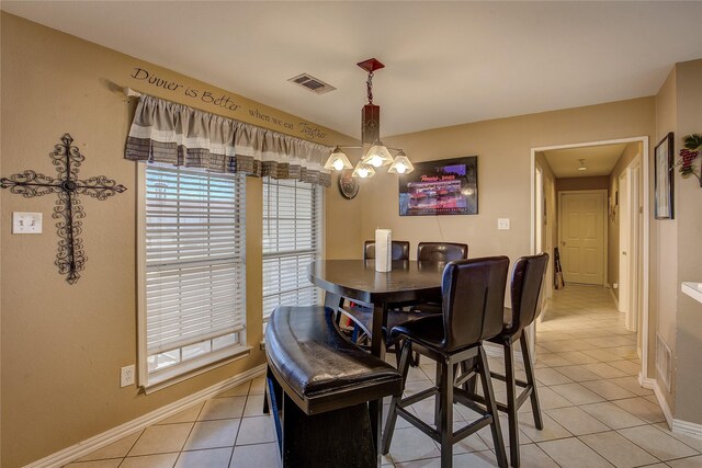 tiled dining space featuring a notable chandelier