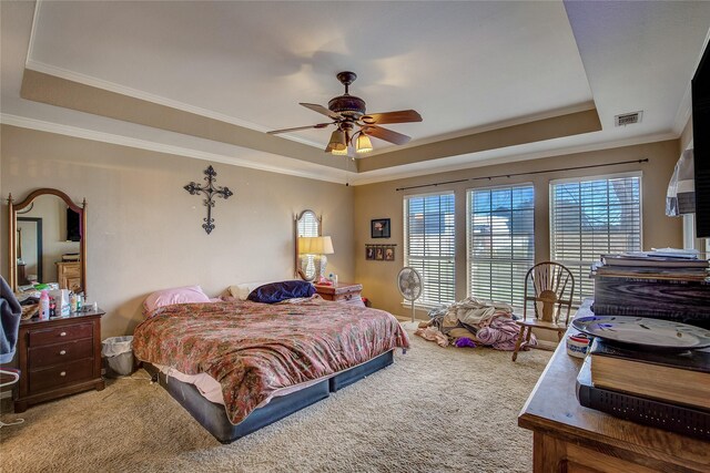 carpeted bedroom with ceiling fan, a raised ceiling, and crown molding