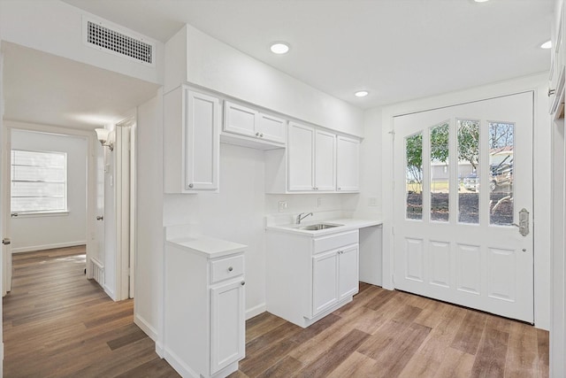 kitchen featuring white cabinets, hardwood / wood-style flooring, and sink