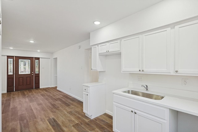 kitchen with white cabinetry, sink, and hardwood / wood-style floors