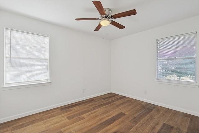 spare room featuring wood-type flooring, plenty of natural light, and ceiling fan