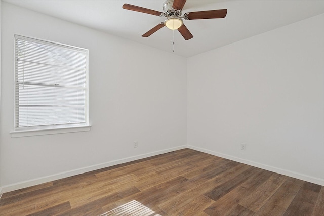 empty room with ceiling fan, a healthy amount of sunlight, and dark hardwood / wood-style floors