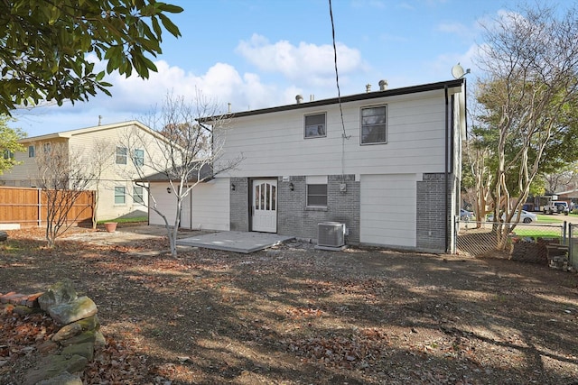 back of property with central AC and a patio