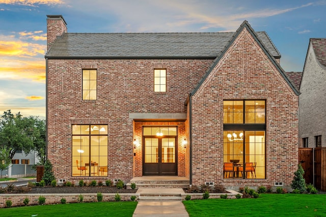 view of front of house with french doors and a yard