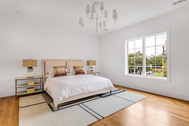 bedroom featuring wood-type flooring and an inviting chandelier