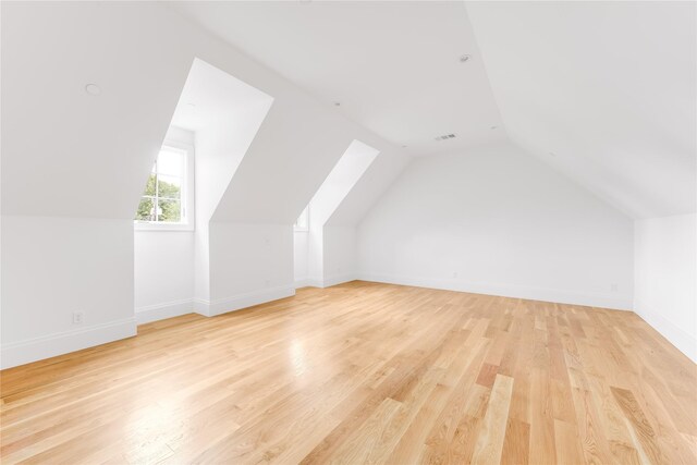 bonus room with light hardwood / wood-style floors and lofted ceiling