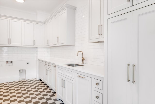 kitchen featuring decorative backsplash, white cabinetry, crown molding, and sink