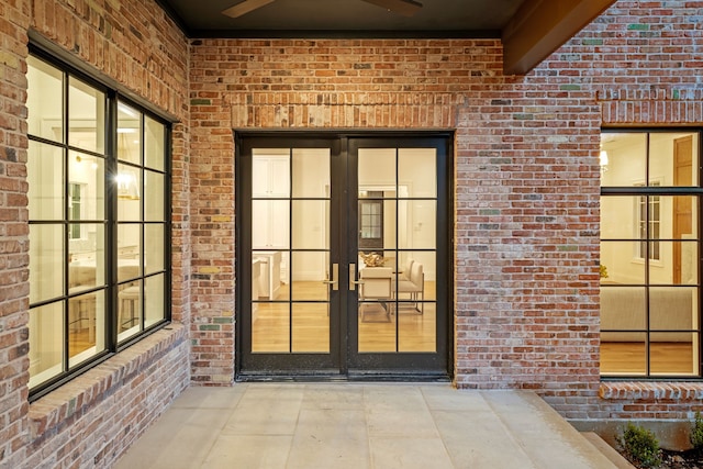 view of exterior entry featuring ceiling fan and french doors