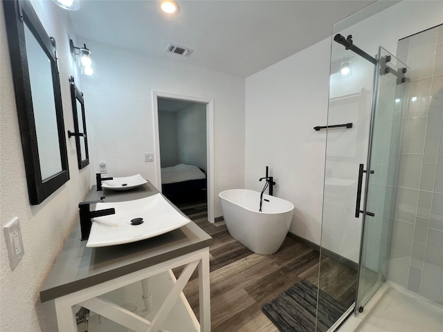 bathroom featuring hardwood / wood-style flooring, vanity, and separate shower and tub