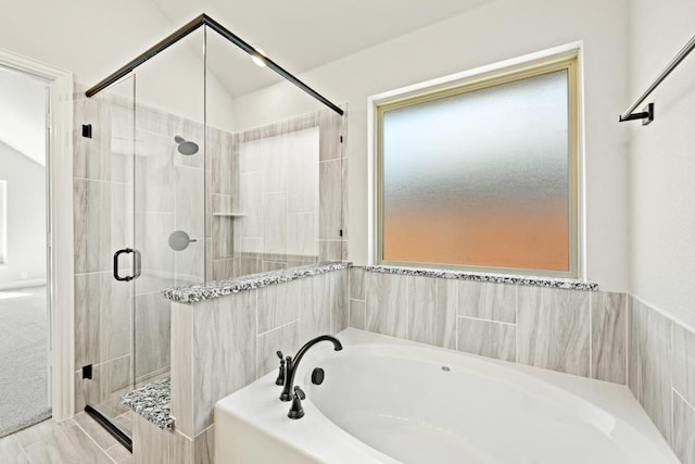 bathroom with a shower stall and a bath