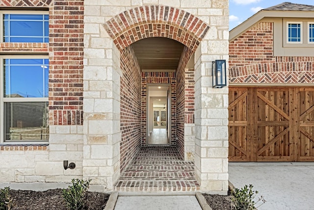 doorway to property with stone siding and brick siding