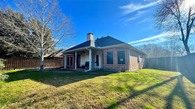 back of house with a lawn and ceiling fan