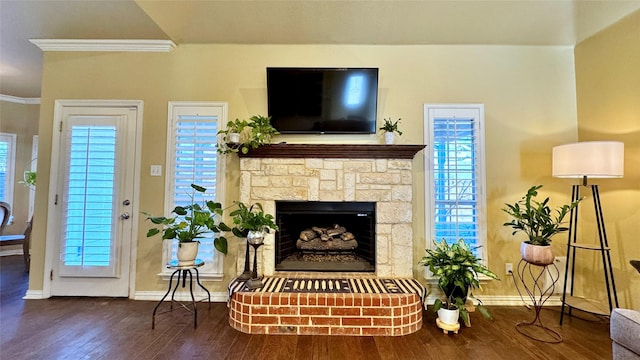 living room with dark hardwood / wood-style flooring, crown molding, and a fireplace