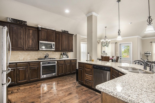 kitchen featuring appliances with stainless steel finishes, light stone counters, and dark brown cabinets