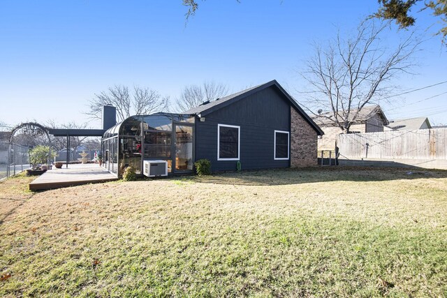 rear view of property featuring a yard and ac unit