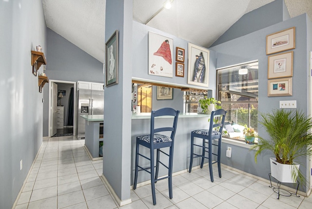 interior space featuring light tile patterned floors and vaulted ceiling