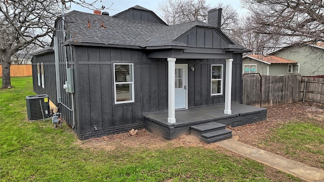 rear view of house with a yard and central AC unit