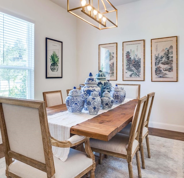 dining area featuring a chandelier, wood finished floors, and baseboards