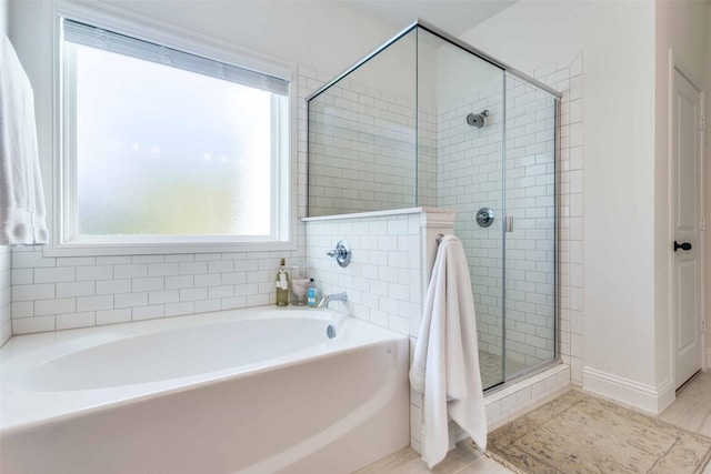 bathroom with a shower stall and a bath