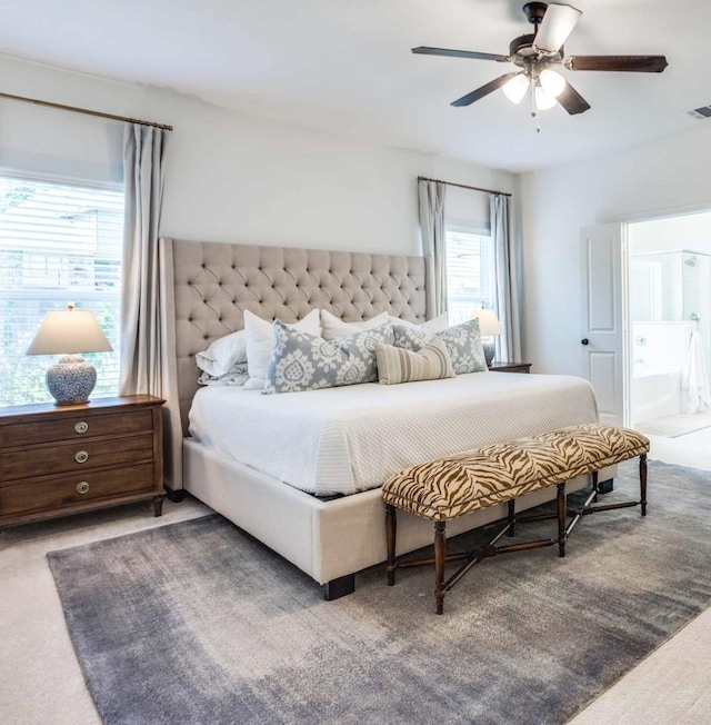 bedroom with carpet, visible vents, ceiling fan, and ensuite bath