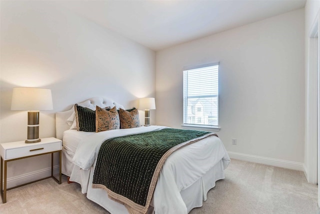 bedroom featuring baseboards and light colored carpet