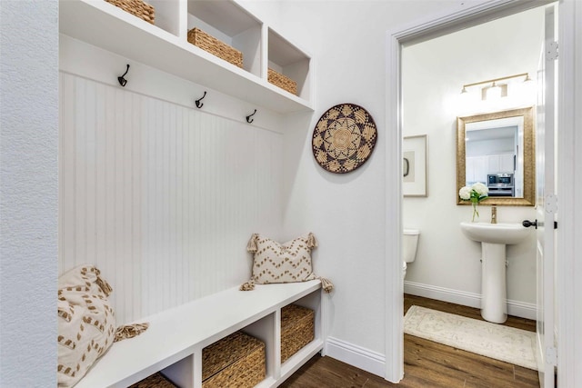 mudroom featuring dark wood-type flooring and baseboards