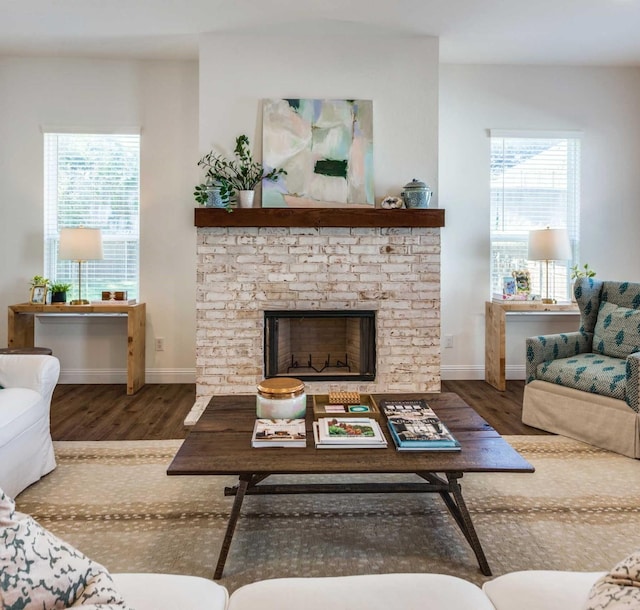 living room featuring a fireplace, baseboards, and dark wood finished floors